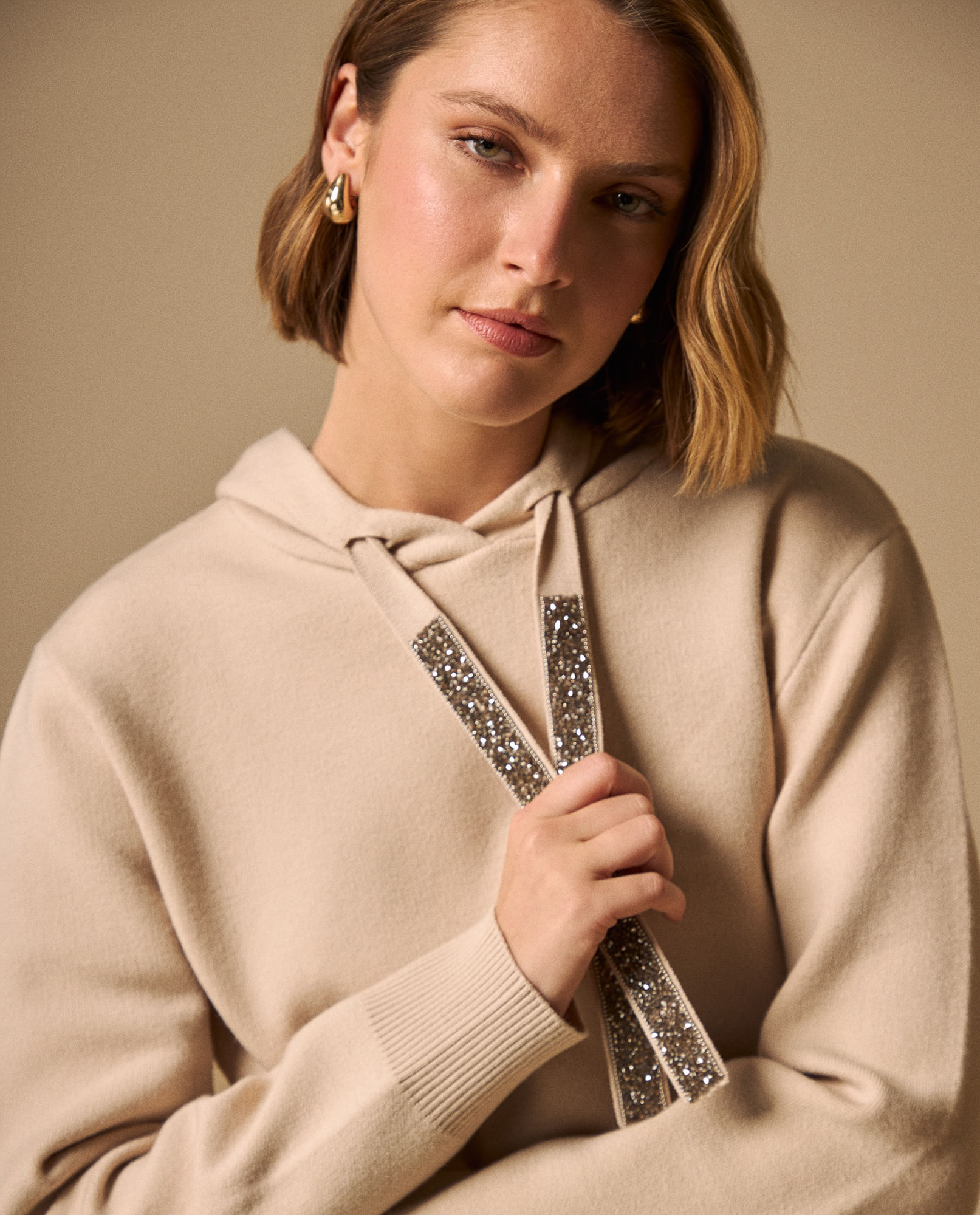 Suéter Beige con Cordones Brillantes y Capucha